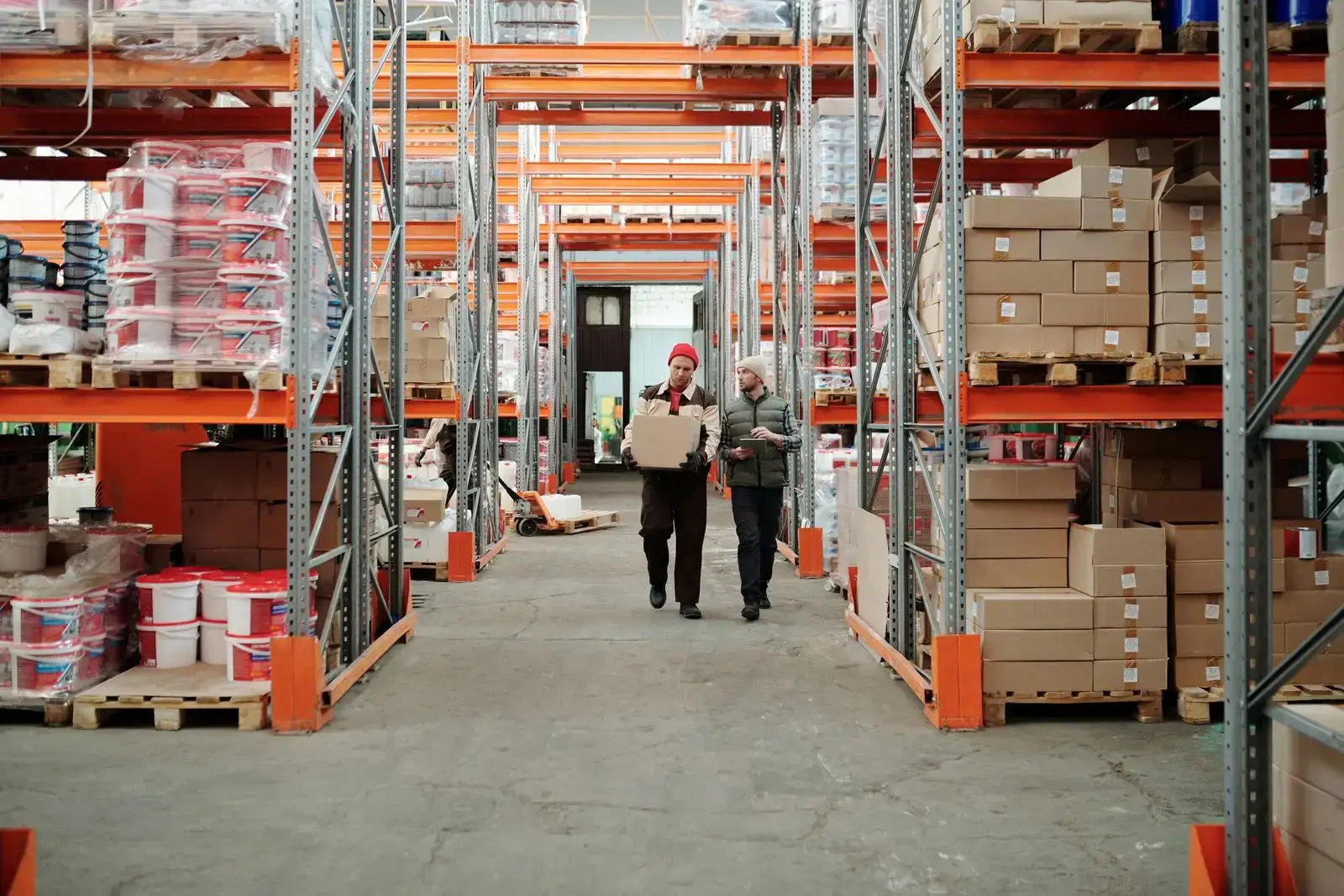Warehouse team walking through a distribution centre lined with tall racking