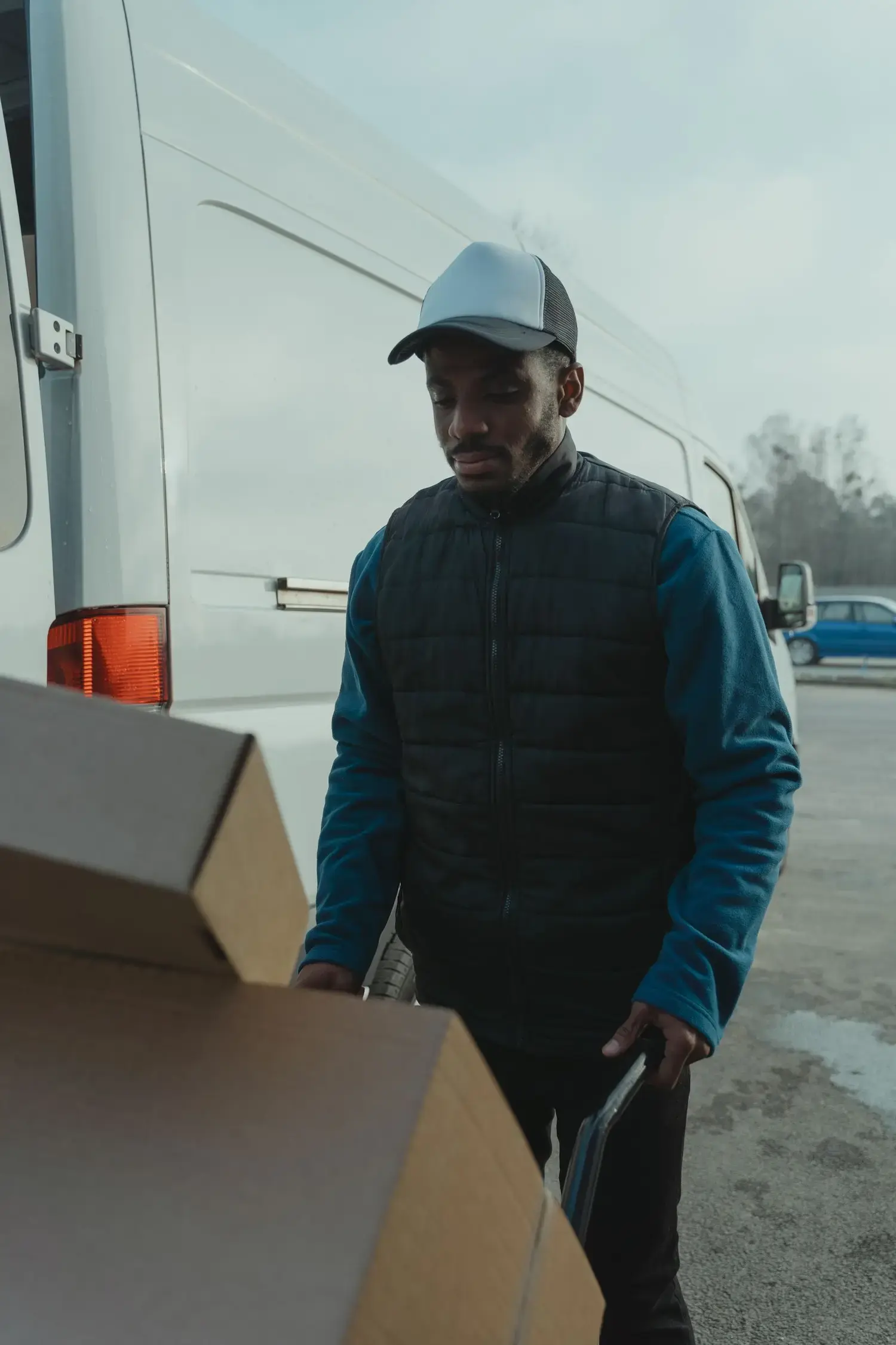 Delivery driver unloading a parcel from a white van