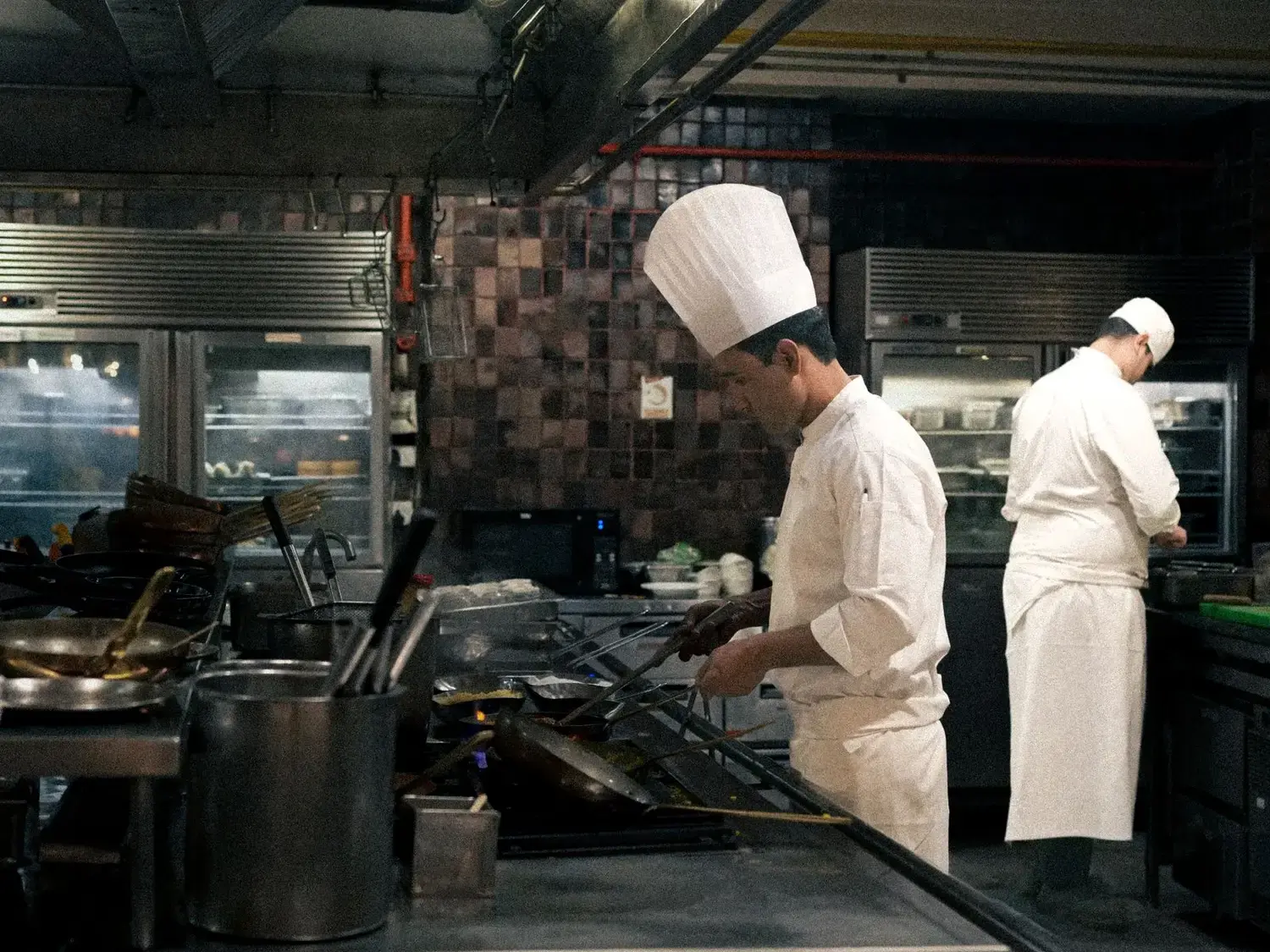 Chefs preparing food in a busy professional kitchen